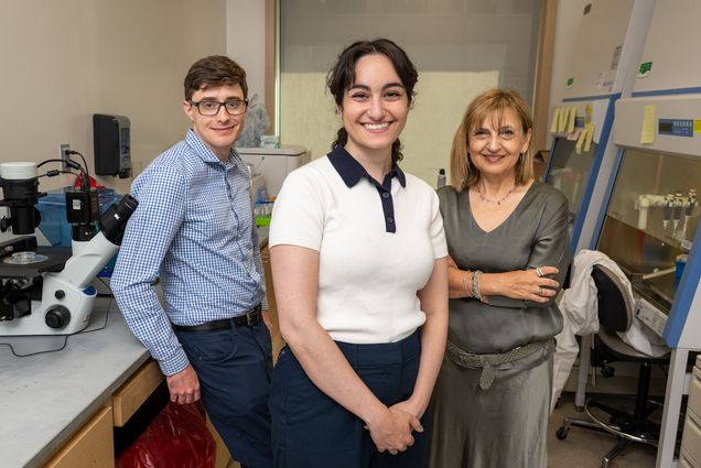 a man and two women standing in a lab wearing street clothes