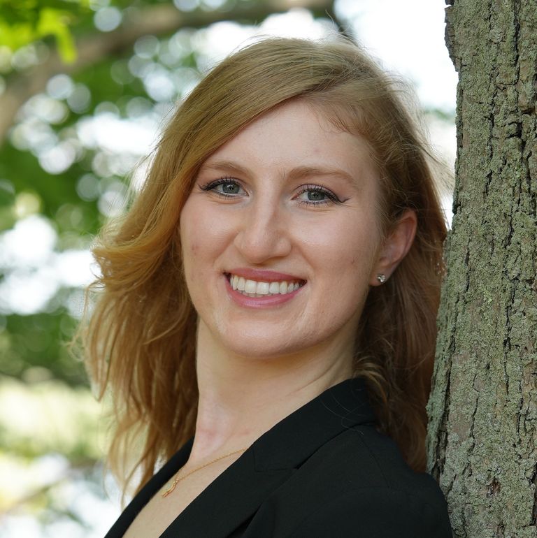 Headshot of Brianna Spiegel by a tree.