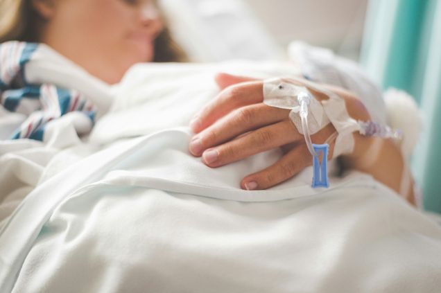patient in hospital bed with IV