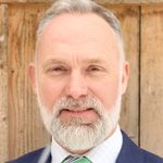 White haired white man with beard, wearing a suit and tie