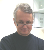 Man with gray hair wearing eyeglasses and black turtleneck