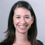 Headshot of woman with shoulder length straight black hair smiling broadly 