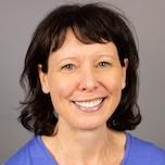 head and shoulders woman with dark shoulder length hair wearing a periwinkle blue shirt