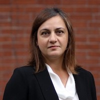 head and shoulders of Maria Argos in front of a brick wall