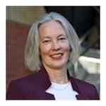 Head and shoulder sot of Maureen Stewart, chin length straight silver hair, smiling broadly, white shirt plum jacket