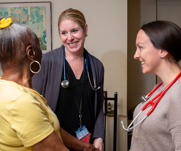 Dr. Chippendale and a fourth-year medical student speaking to a caregiver.