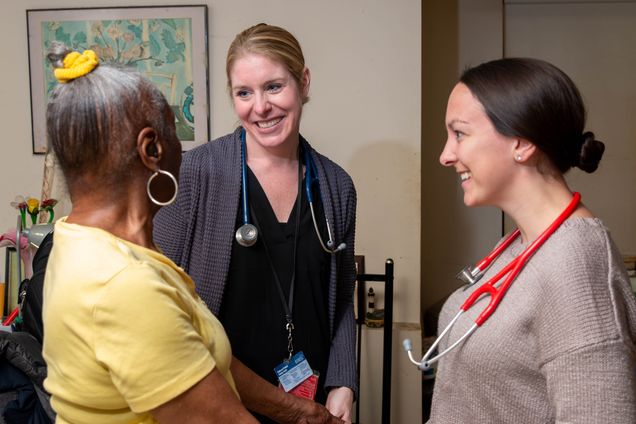 Dr. Chippendale and a fourth-year medical student speaking to a caregiver.