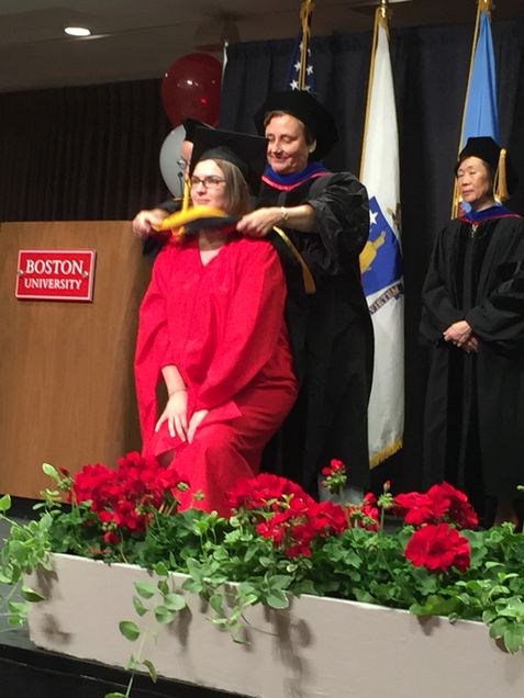 student and faculty member at graduation