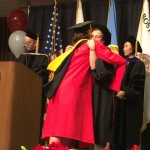 student hugging a faculty member at graduation