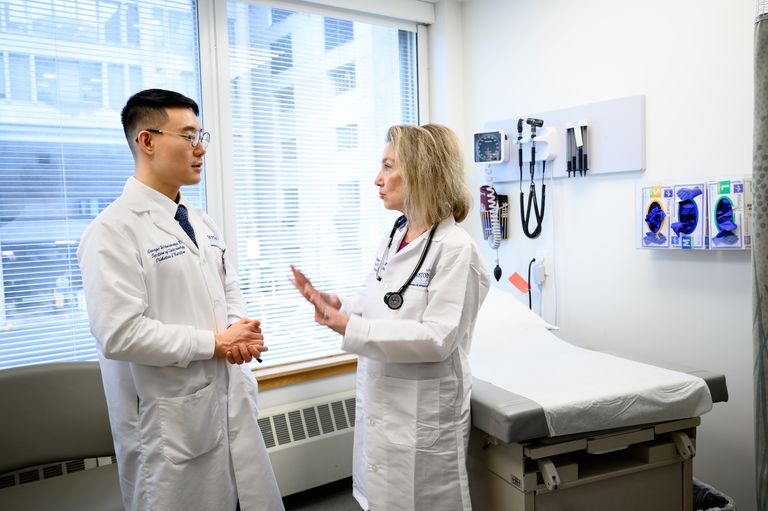 Two clinicians speaking in exam room