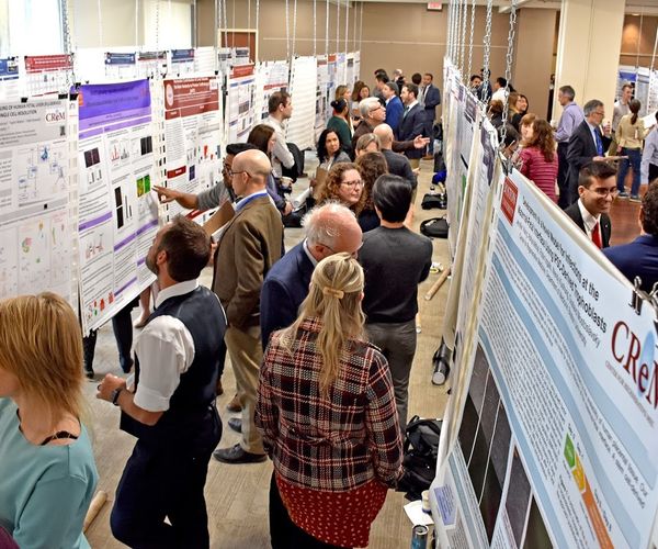 Many people walking around looking at posters in hiebert Lounge