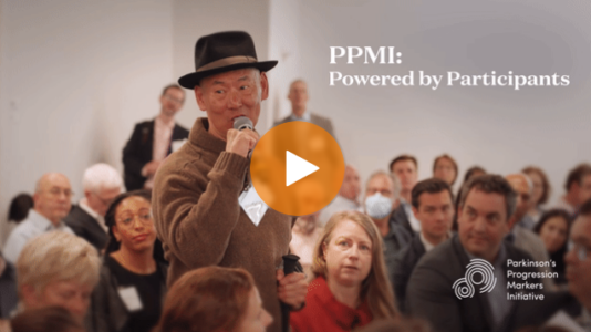 A gentleman at the PPMI annual meeting uses a microphone to tell his story